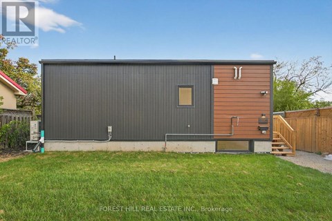 A modern building with a grey exterior and a brown wooden exterior is shown.