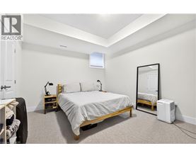 A bedroom with a bed, nightstand, and a mirror.