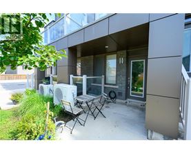 A patio with a table and chairs is in front of a modern building.