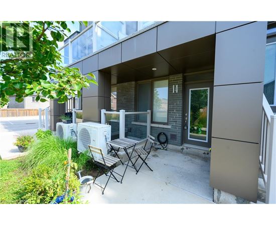 A patio with a table and chairs is in front of a modern building.