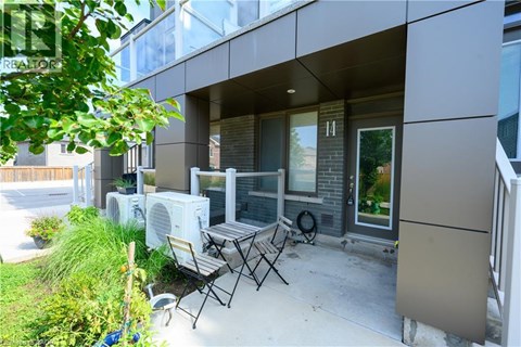 A patio with a table and chairs is in front of a modern building.