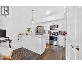 A modern kitchen with white cabinets and stainless steel appliances.