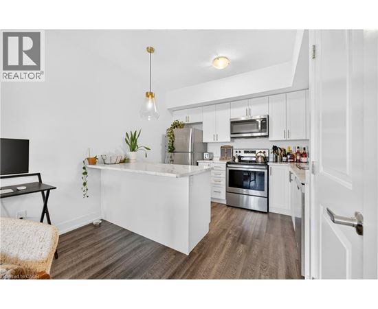 A modern kitchen with white cabinets and stainless steel appliances.