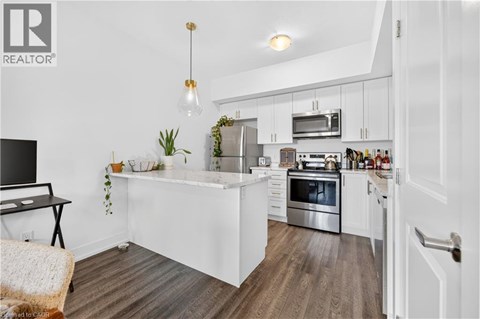 A modern kitchen with white cabinets and stainless steel appliances.