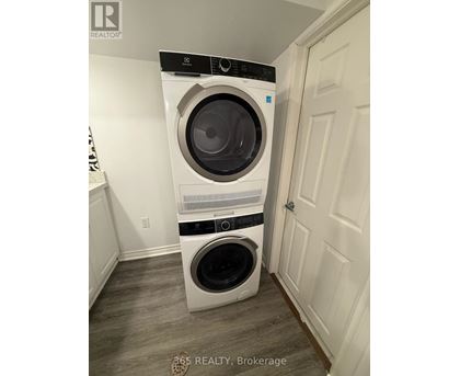 A white front loading washing machine in a laundry room.