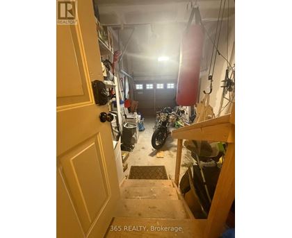 A motorcycle is parked in a garage with a door open.