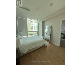 A bedroom with a large bed and a large window.