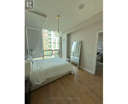 A bedroom with a large bed and a large window.