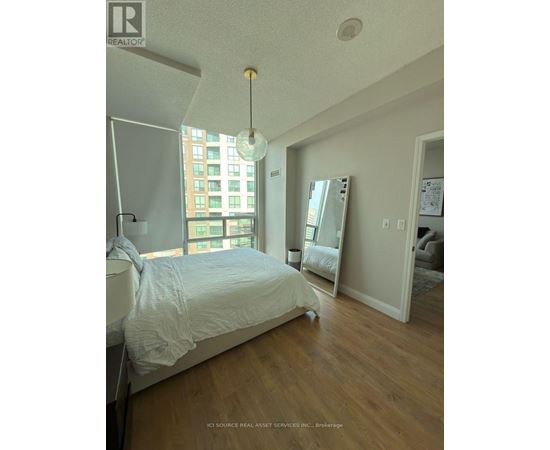 A bedroom with a large bed and a large window.