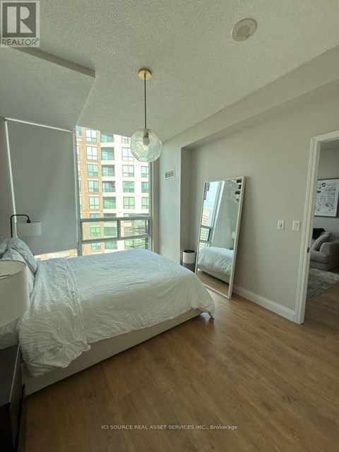 A bedroom with a large bed and a large window.
