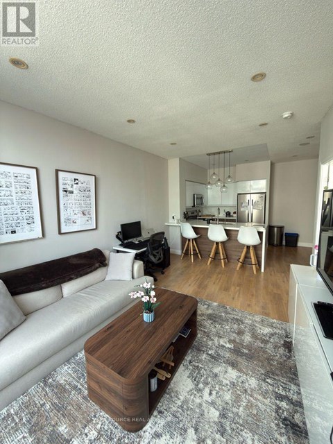 A living room with a white couch and a coffee table in the middle.