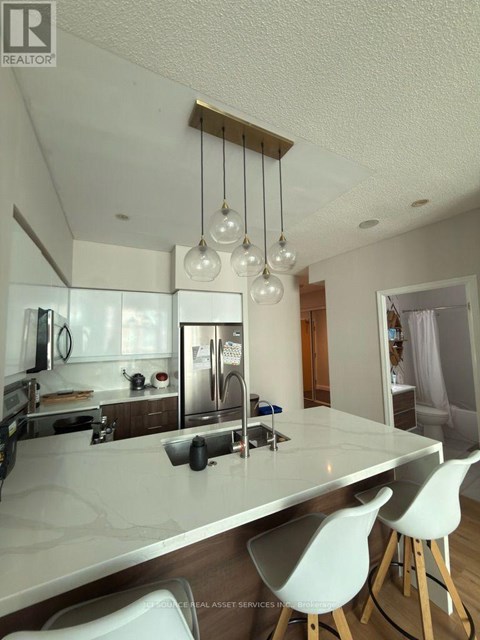 A modern kitchen with white cabinets and a marble countertop.
