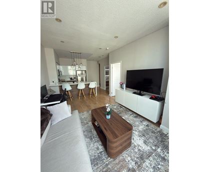 A living room with a grey couch and a wooden coffee table.