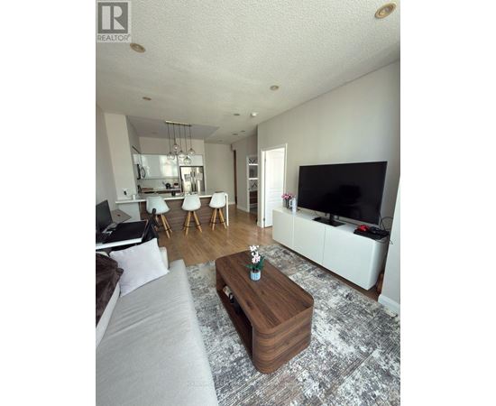 A living room with a grey couch and a wooden coffee table.
