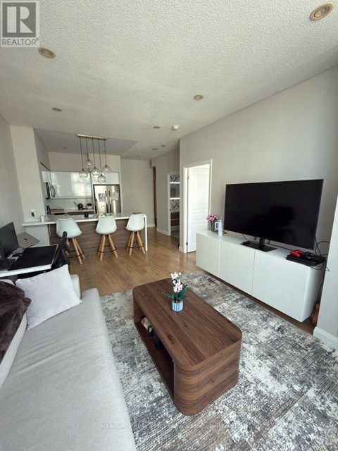 A living room with a grey couch and a wooden coffee table.