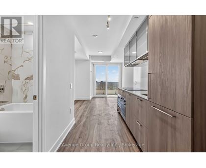 A modern kitchen with wooden floors and white walls.
