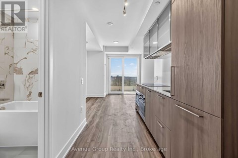 A modern kitchen with wooden floors and white walls.