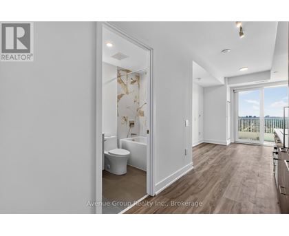 A bathroom with a toilet, sink, and a window overlooking a balcony.
