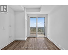 A white room with a sliding glass door leading to a balcony.