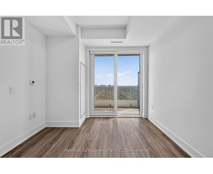A white room with a sliding glass door leading to a balcony.