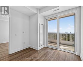 A large, empty room with a sliding glass door leading to a balcony.