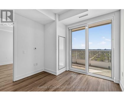 A large, empty room with a sliding glass door leading to a balcony.