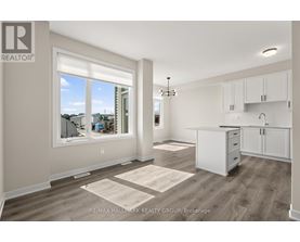 A well-lit, spacious kitchen and living room with a view of the outdoors through a large window.