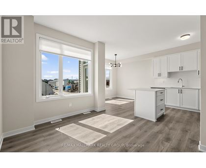 A well-lit, spacious kitchen and living room with a view of the outdoors through a large window.