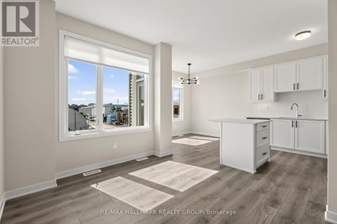 A well-lit, spacious kitchen and living room with a view of the outdoors through a large window.