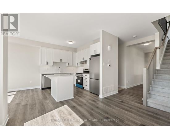 A kitchen with white cabinets and a wooden floor.
