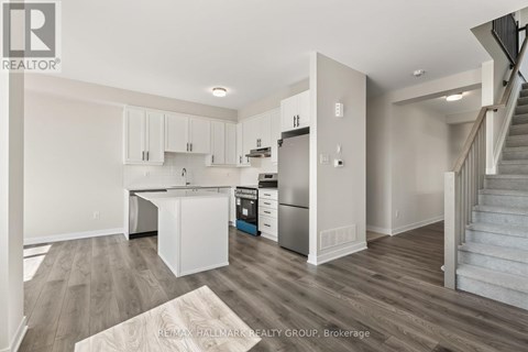 A kitchen with white cabinets and a wooden floor.