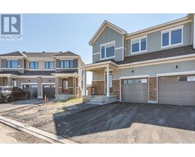 A brokerage sign is displayed in front of a row of houses.