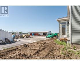 A construction site with a building and a green truck in the background.