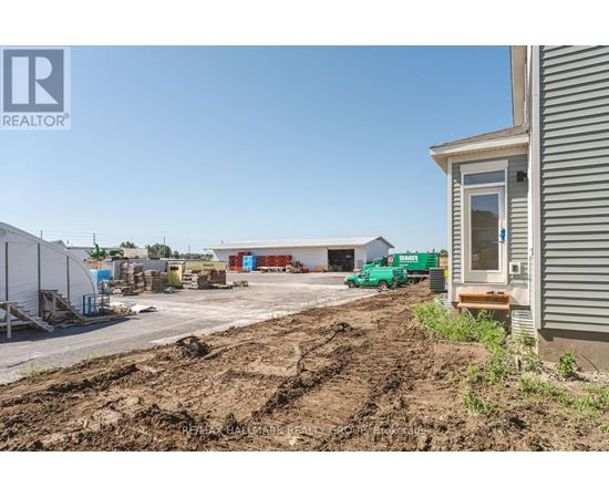 A construction site with a building and a green truck in the background.