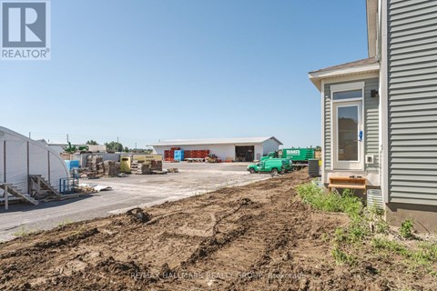 A construction site with a building and a green truck in the background.