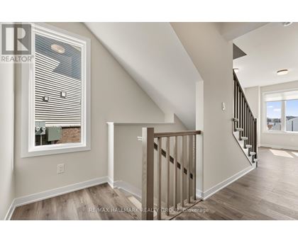 A spacious room with a staircase leading to another room.