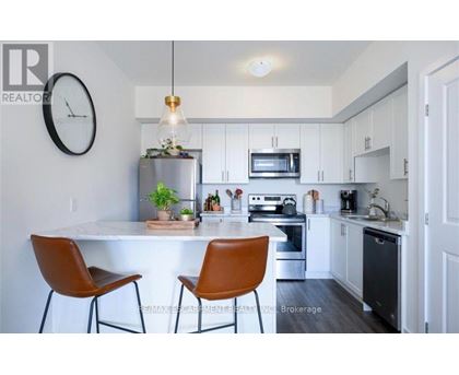 A modern kitchen with a white countertop and brown chairs.