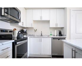A kitchen with white cabinets and a black stove top.