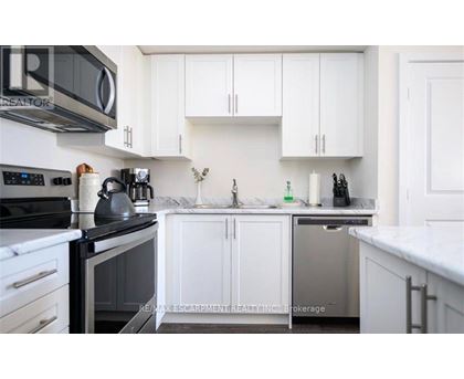 A kitchen with white cabinets and a black stove top.