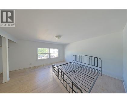 A bedroom with a bed and a window.