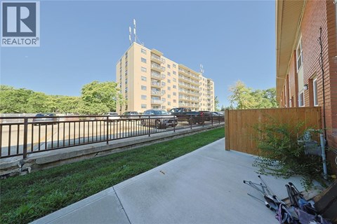 A view of a residential area with apartment buildings, a sidewalk, and a parked car.