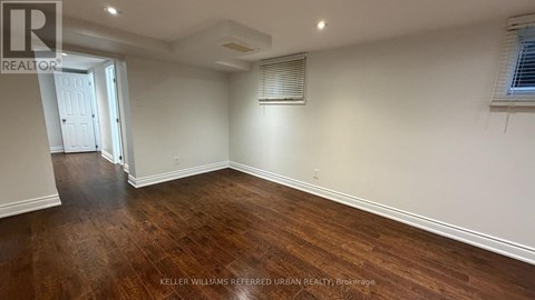 A room with wooden flooring and white walls.