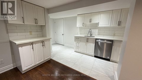 A kitchen with white cabinets and a stainless steel dishwasher.