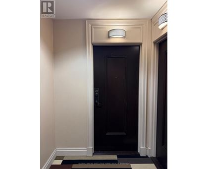 A dark brown door with a silver handle and a small light above it.