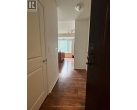 A hallway with a door on the right and a window in the distance.