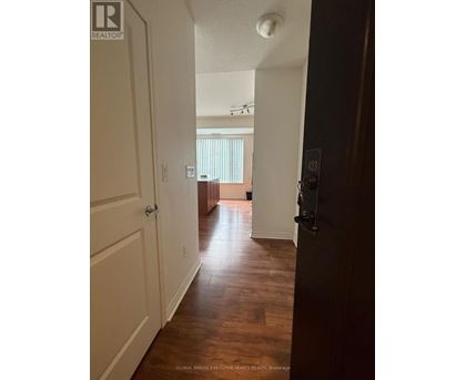 A hallway with a door on the right and a window in the distance.