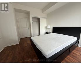 A bedroom with a large bed and wooden floors.