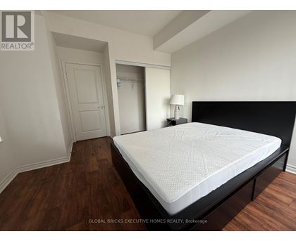 A bedroom with a large bed and wooden floors.