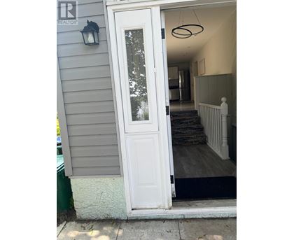 A white door with a glass window is open.