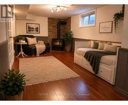 A cozy living room with a wood stove and a couch.